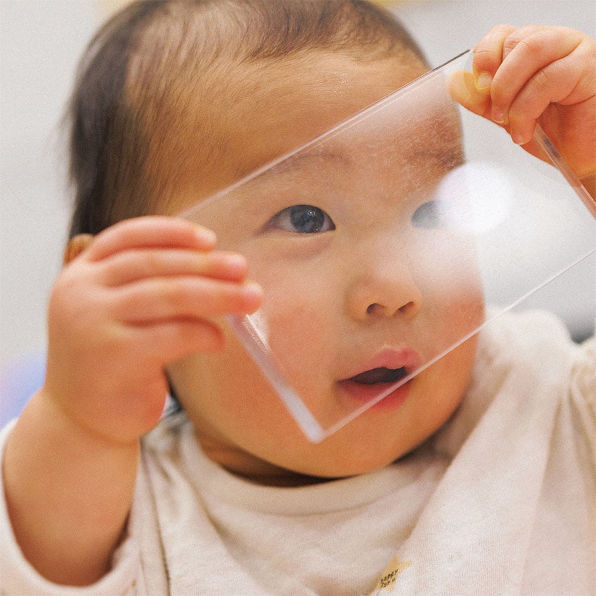 透明な板を通して世界を見つめる赤ちゃん